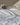 Champagne silk pillowcase on layered cream bedding in morning light.