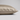 A close-up of a pillowcase in champagne silk, showing its smooth texture and hidden zipper detail, set against a neutral light gray background.