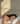 A woman with long dark hair rests her head on an ivoery ZILK silk pillow, wearing a white silk camisole and white silk bedding in a softly lit bedroom.