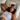 Woman laying in bed with a dark gray ZILK silk sleep mask over her forehead with her head on a white silk pillowcase.