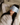 Woman with a light blue ZILK silk sleep mask over her eyes laying in bed with her head on an ivory silk pillowcase. 