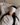 Woman wearing a light gray ZILK silk sleep mask over her eyes laying in bed with her head on a white silk pillowcase.