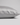 A close-up of a pillowcase in light gray silk, showing its smooth texture and hidden zipper detail, set against a neutral light gray background.