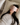 Woman wearing a light pink ZILK silk sleep mask over her eyes laying in bed with her head on an ivory silk pillowcase.