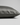 A close-up of a pillowcase in dark gray silk, showing its smooth texture and hidden zipper detail, set against a neutral light gray background.
