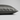 A close-up of a pillowcase in dark gray silk, showing its smooth texture and hidden zipper detail, set against a neutral light gray background.