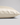 A close-up of a pillowcase in ivory silk, showing its smooth texture and hidden zipper detail, set against a neutral light gray background.