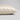 A close-up of a pillowcase in ivory silk, showing its smooth texture and hidden zipper detail, set against a neutral light gray background.